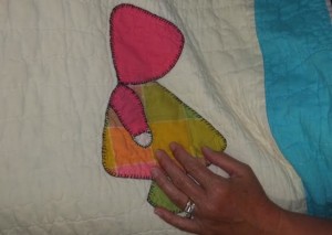 Valerie Smith Miklozek ’s hand  with her family Dutch Doll Quilt